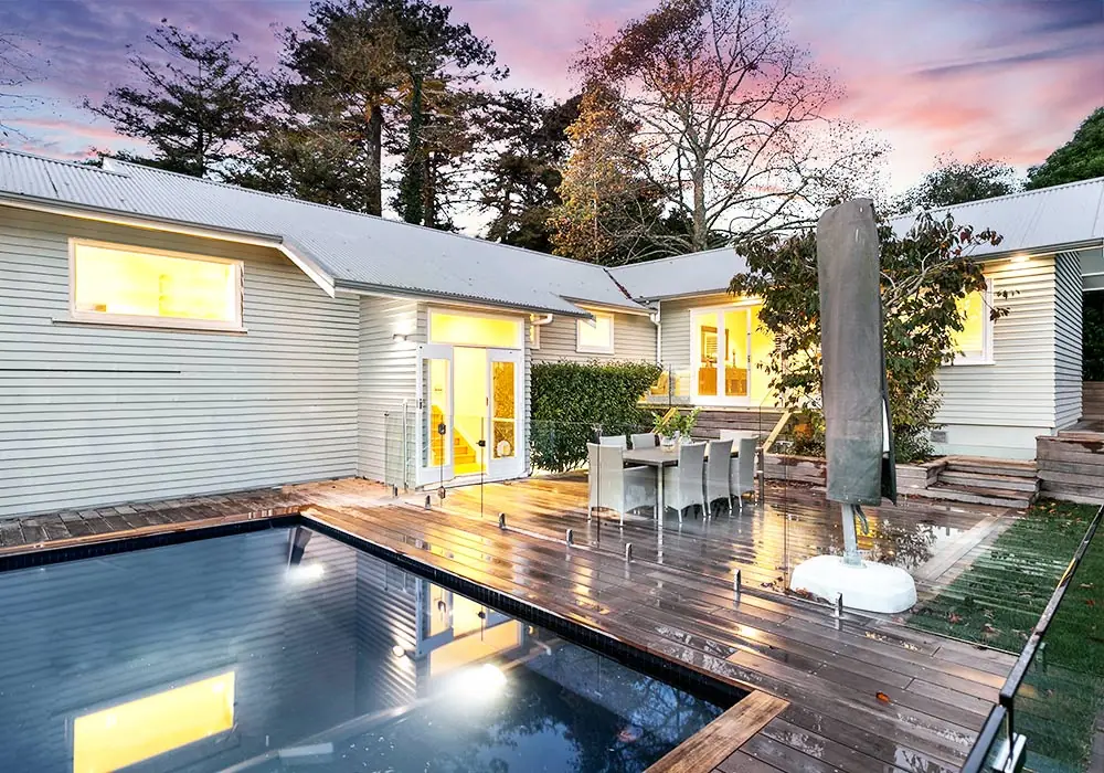 Renovated Remuera bungalow with hardwood deck and pool at dusk